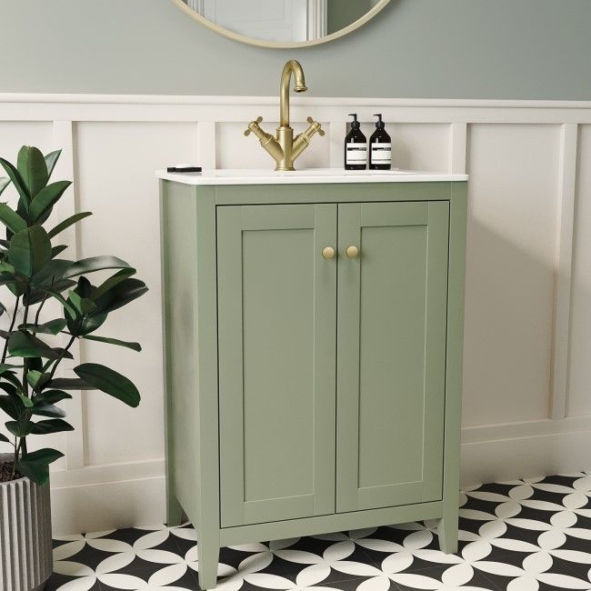 a bathroom with a sink, mirror and potted plant on the floor in front of it