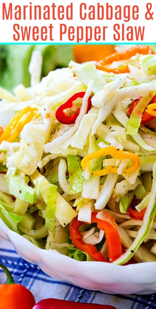 a close up of a salad in a bowl with peppers on the side and text overlay that reads marinated cabbage and sweet pepper slaw