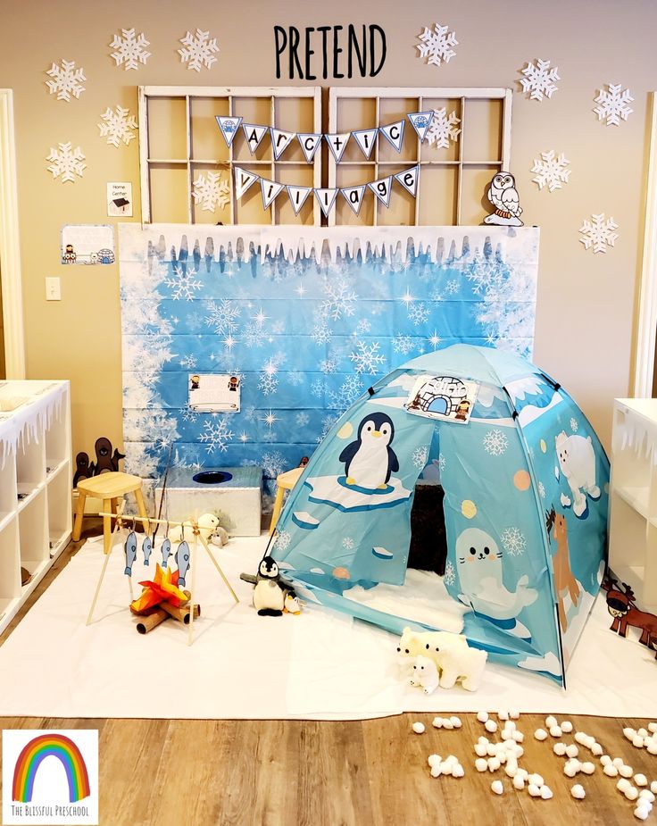 there is a penguin tent in the room with snowflakes on the wall behind it