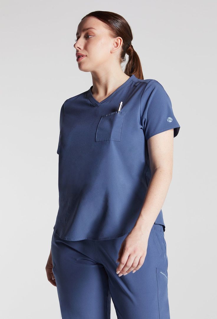 MADE FOR THE WAY YOU MOVE™: A classic short sleeve scrub top you will wear over and over again, in buttery-soft lightweight, stretchy fabric. The flattering shirt tail hem with a classic fit and room for layering when you want a bit more coverage. A badge tab, well-placed functional pockets, reflective branding for safety and a water-repellent treatment to get you through your shift. These scrubs are breathable, wash up like new and customers rave over the flattering fit. Bonus: They are made wi Slim Suit Pants, Wrap Tunic, Womens Golf Shirts, Women's Uniforms, Slim Suit, Cropped Linen Pants, Rise Above, Workout Jacket, Scrub Tops