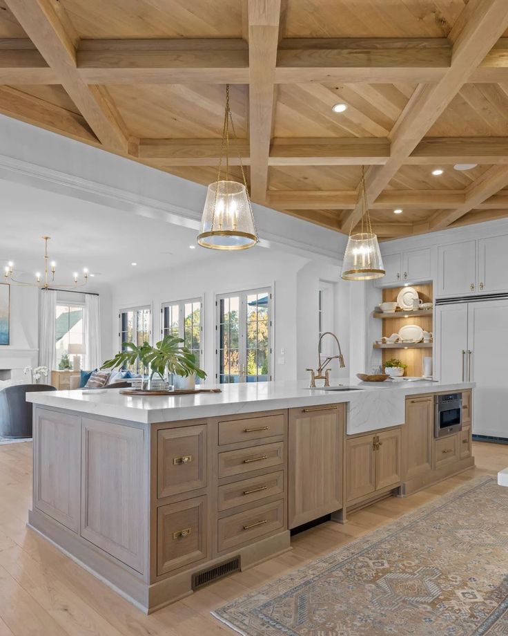 a large kitchen with an island in the middle and wooden beams on the ceiling above it