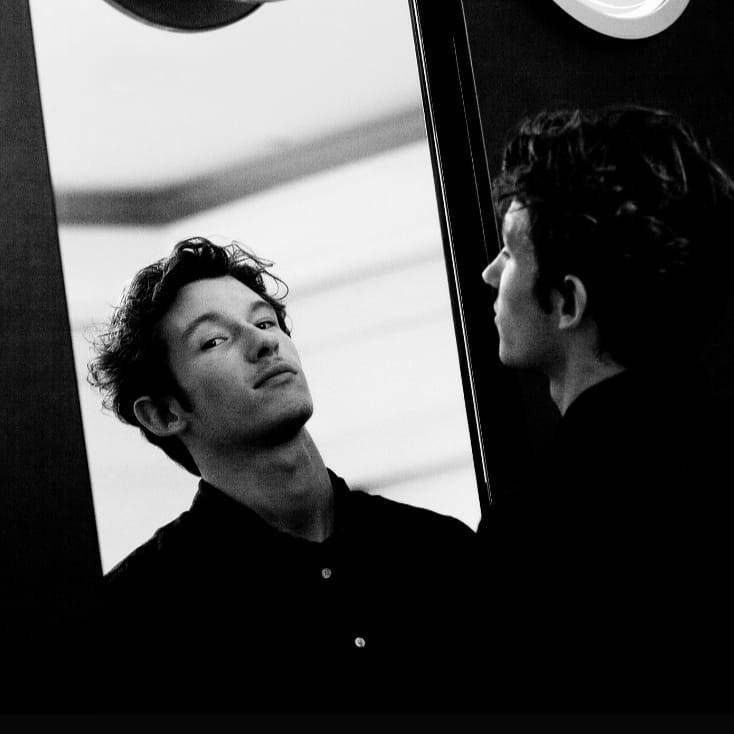 two men are looking at each other in the mirror