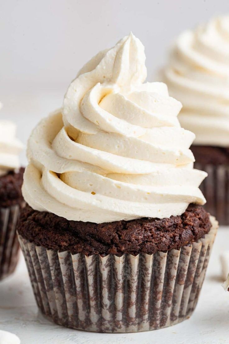 chocolate cupcakes with white frosting on top