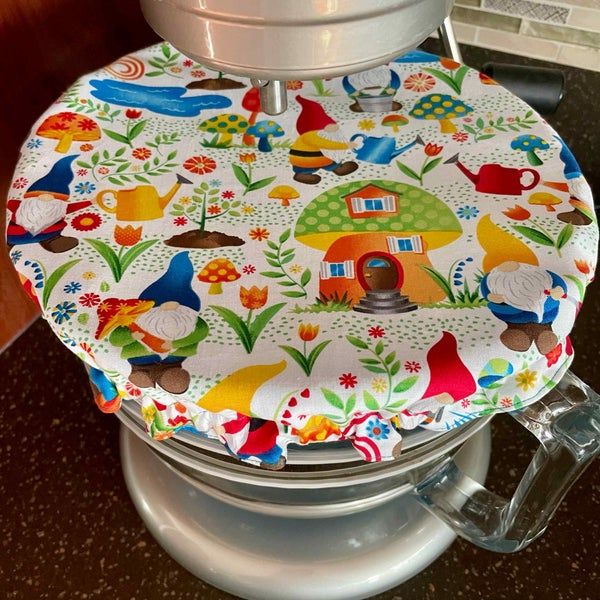 a colorful toilet seat cover on top of a metal trash can with an open lid