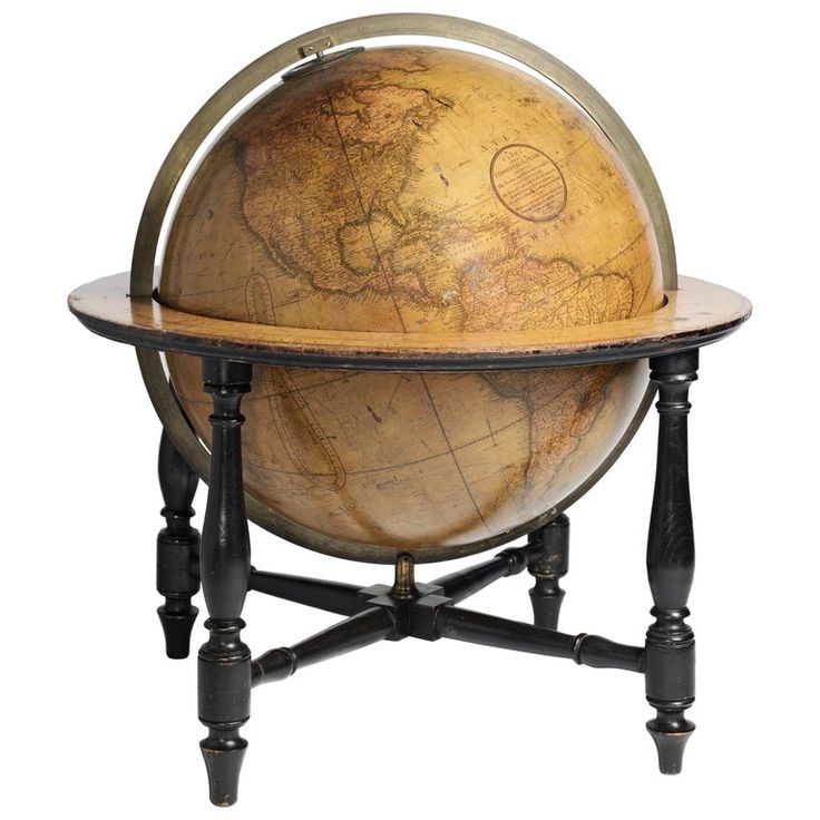 an old world globe sitting on top of a wooden stand