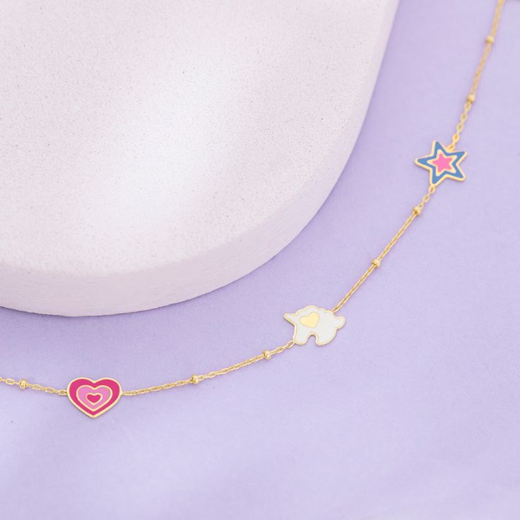 This magical unicorn charm bracelet is fit for a princess! Featuring multi-colored enamel on each of its charms, this bracelet is a happy burst of color that will brighten up any outfit. Made from 14k yellow gold, a material safe for sensitive skin, this bracelet measures 5 inches with an additional 1-inch extension, making it adjustable to fit her small wrist. The unicorn charms add a touch of whimsy to the bracelet, making it adorable for any little girl who loves all things magical. Give the Playful Pink Jewelry With Removable Charms, Playful Multicolor Jewelry With Removable Charms, Playful Pink Enamel Jewelry, Playful Multicolor Jewelry With Star Charm, Playful Star Charm Jewelry For Gifts, Playful Jewelry With Star Charm For Gift, Playful Pink Jewelry With Star Charm, Unicorn Bracelet, Kids Bracelet