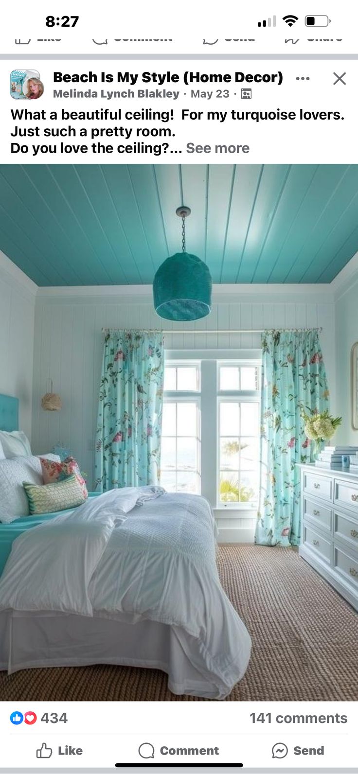 a bed room with a neatly made bed next to a window and a blue ceiling