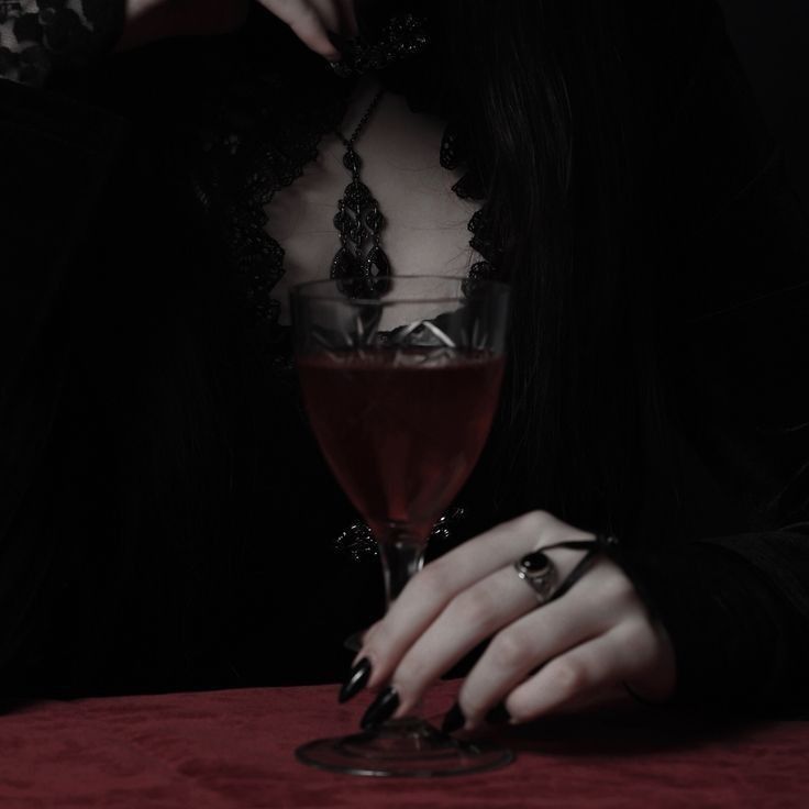 a woman sitting at a table with a glass of wine