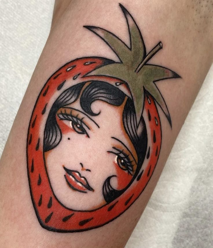 a woman's arm with a tattoo design on it, featuring a red tomato