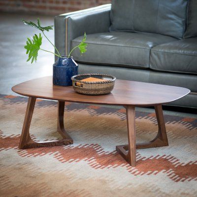 a living room with a couch, table and potted plant on the coffee table