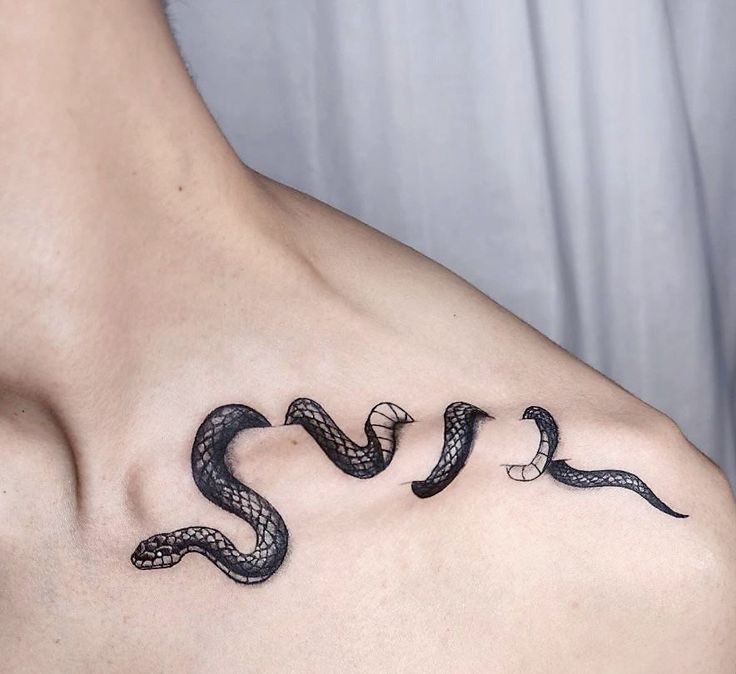 a man's chest with three snakes on it and the word love spelled in cursive writing