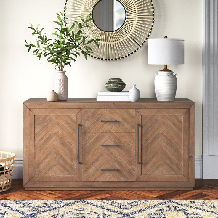 a sideboard with two vases and a mirror on the wall above it in a living room