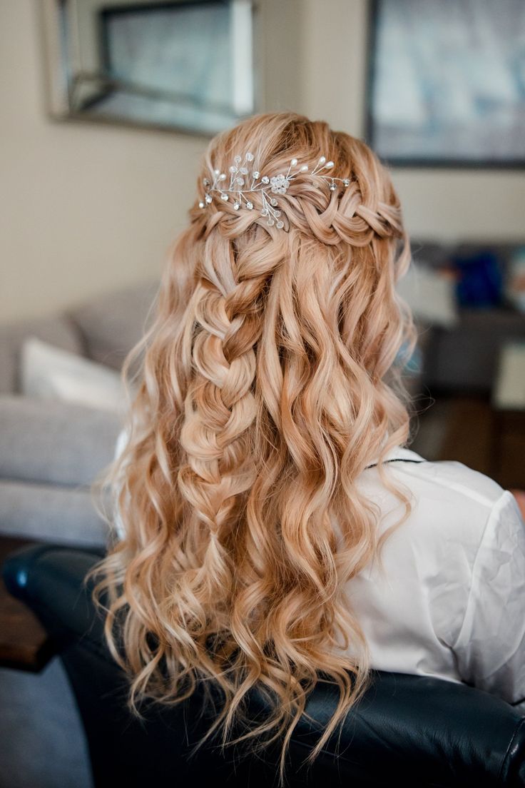 the back of a woman's head with long curly hair and a tiara