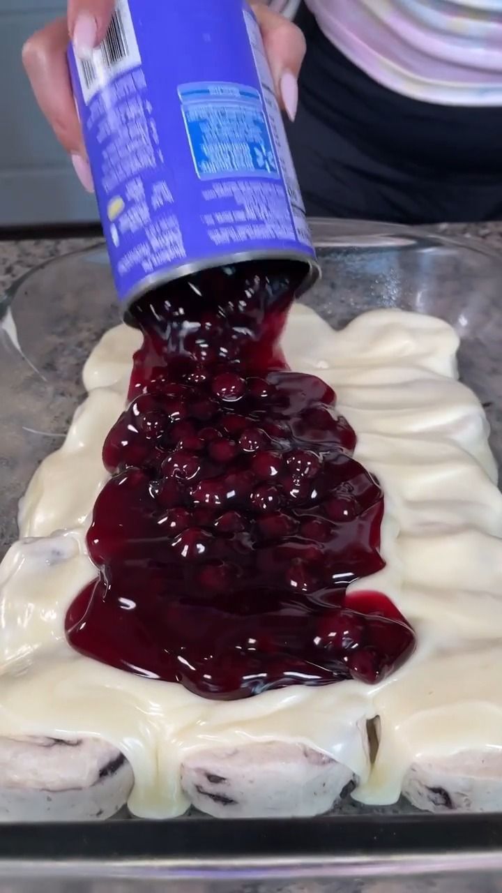 someone is pouring blueberry sauce on some food