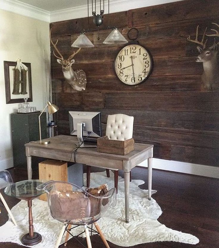 a room with two desks and several deer heads on the wall