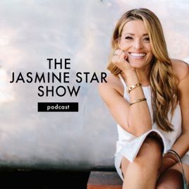 a woman sitting on top of a wooden bench next to a white wall with the words the jasmine star show