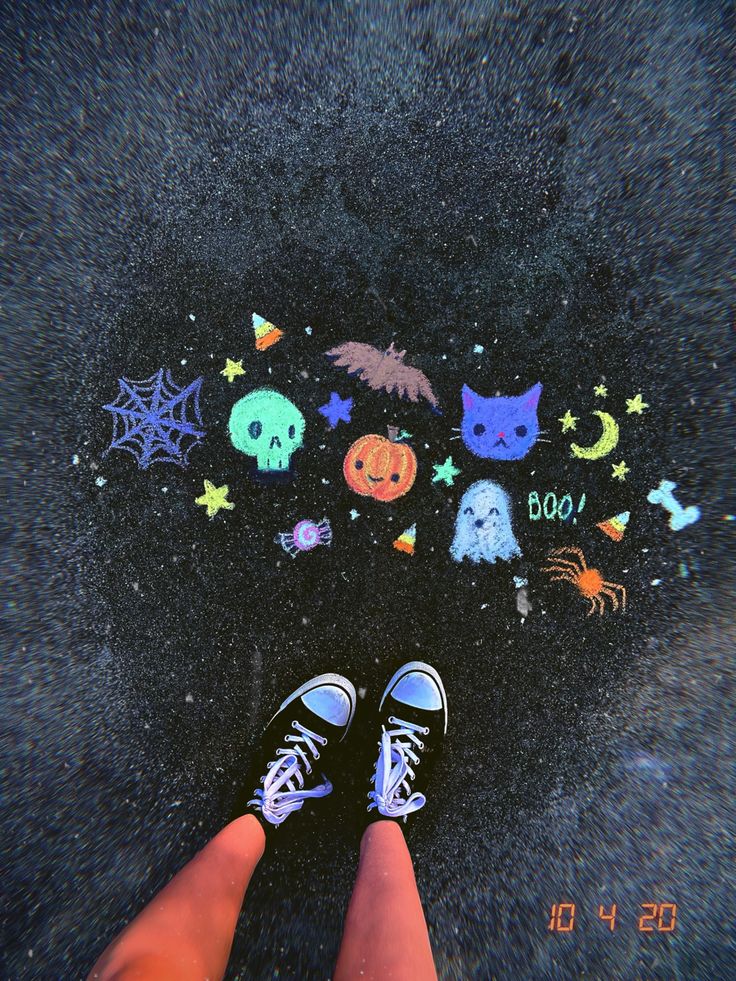 someone is standing on the pavement with their feet in front of some halloween stickers