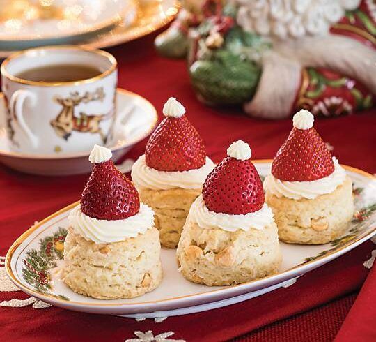 three desserts with strawberries on top are sitting on a plate next to a cup and saucer