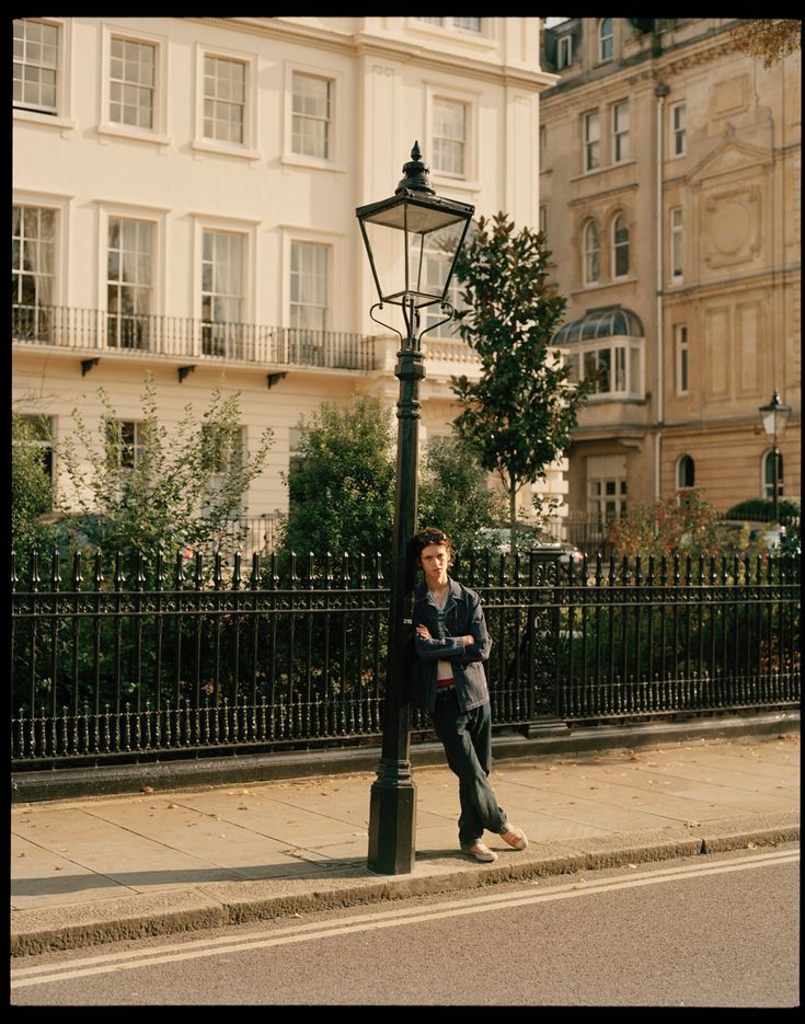 a man standing next to a lamp post