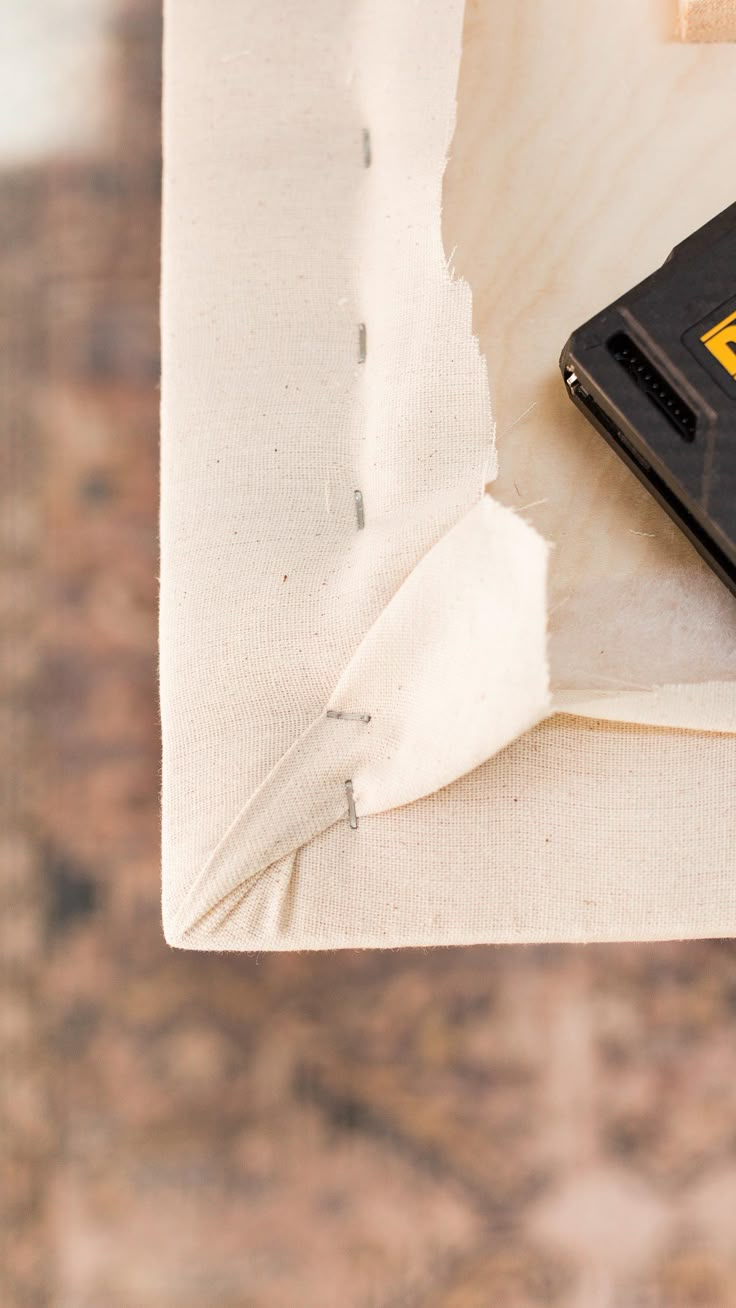 a cell phone sitting on top of a table next to a piece of white paper