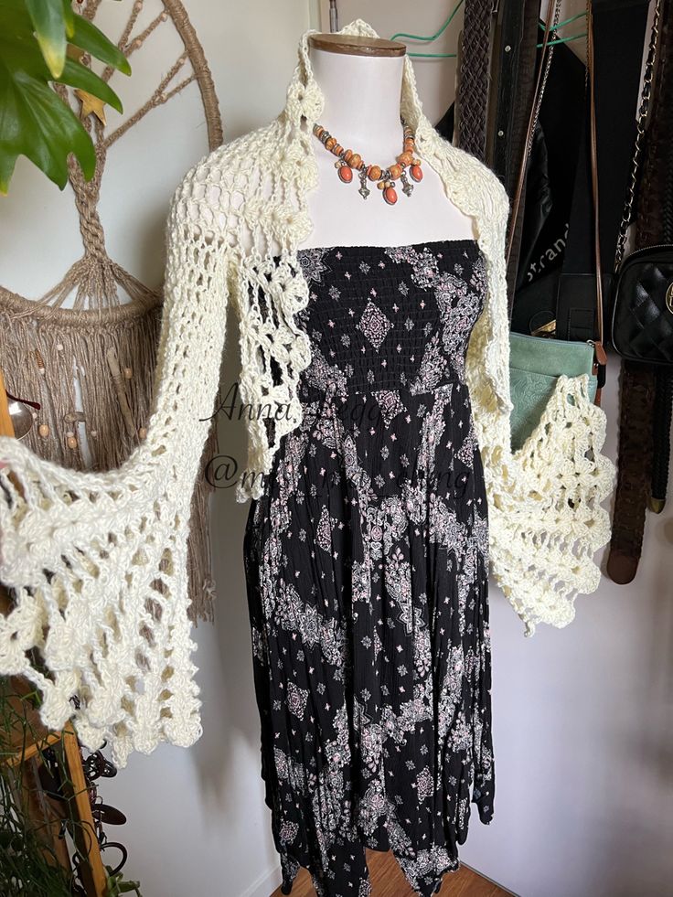 a black and white dress on a mannequin next to a potted plant