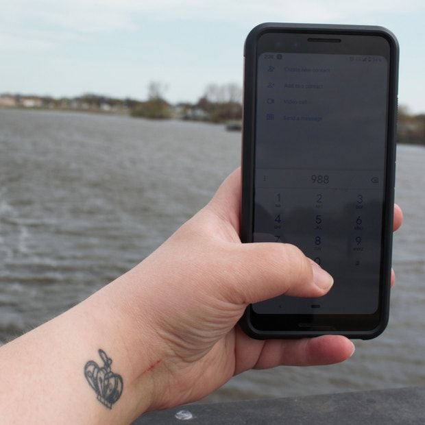 a person holding up a cell phone with a tattoo on it's arm and wrist