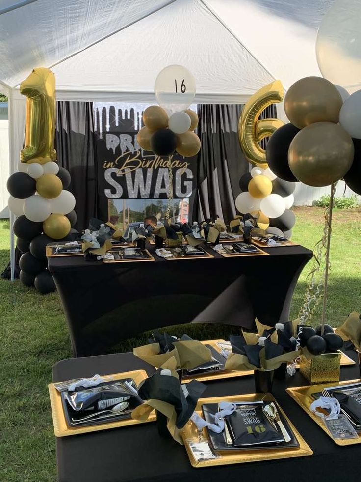 a black and gold party table with balloons