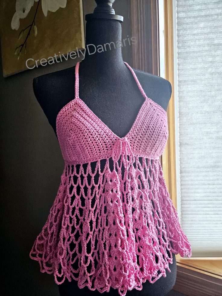 a pink crocheted halter top on a mannequin