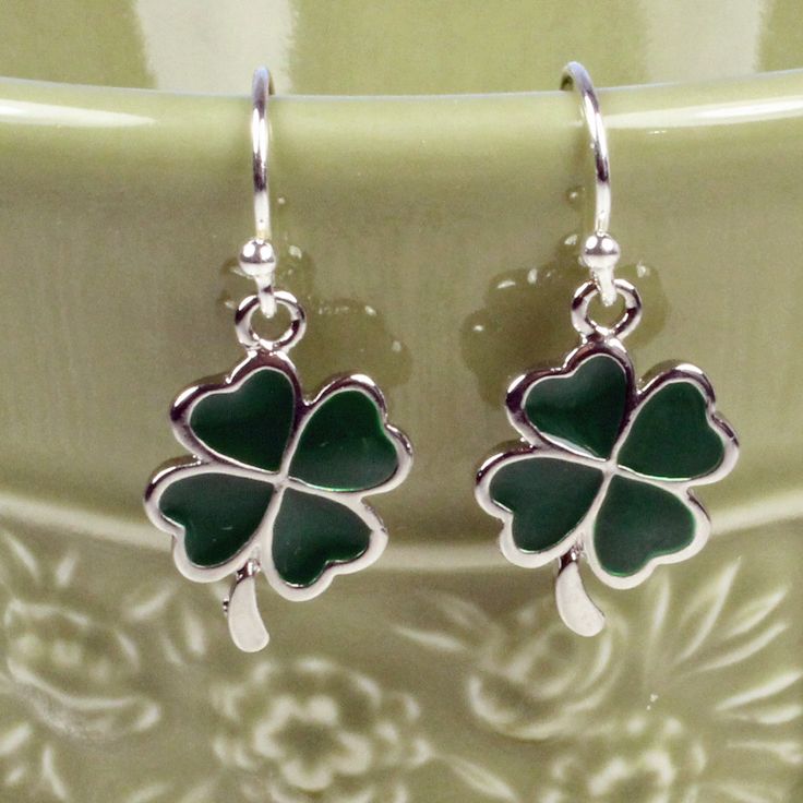 "Cute, simple and dainty green enamel shamrock charms dangle .5\" (1 cm) from sterling silver ear wires. ❖ enamel shamrock charms ❖ sterling silver ear wires ❖ rubber stoppers Earrings shown are on french hook ear wires. All earring types are sterling silver with the exception of clip-ons, which are silver plated." Green Charms Jewelry Perfect For Gifts, Nickel-free Enamel Drop Earrings, Green Sterling Silver Dangle Earrings, Green Charms Jewelry For Good Luck, Adjustable Green Enamel Jewelry, Green Teardrop Sterling Silver Jewelry, Nickel-free Green Sterling Silver Jewelry, Green Dainty Dangle Earrings, Nickel-free Green Jewelry In Sterling Silver