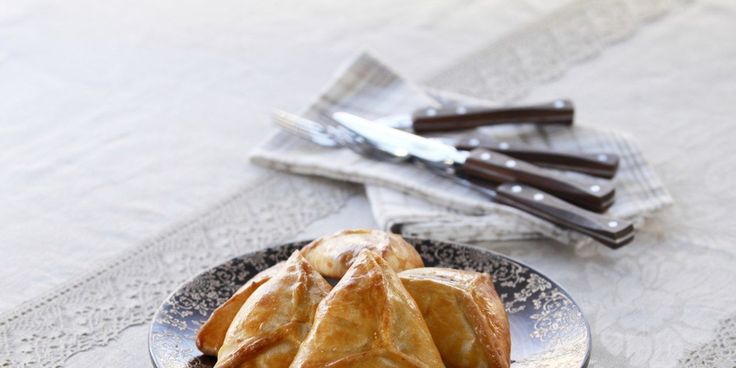 two pastries on a plate next to a knife and napkin