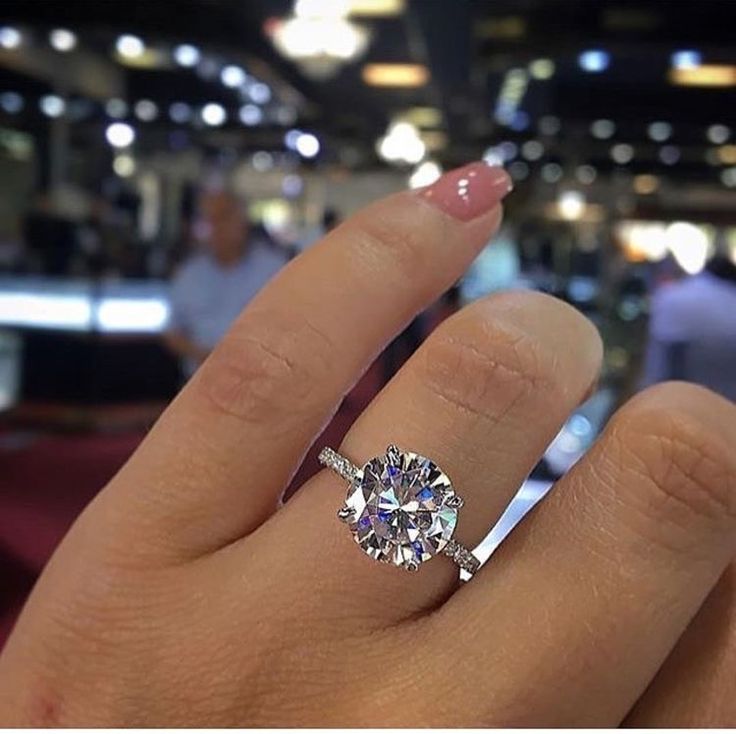 a woman's hand with a ring on it and a diamond in the middle