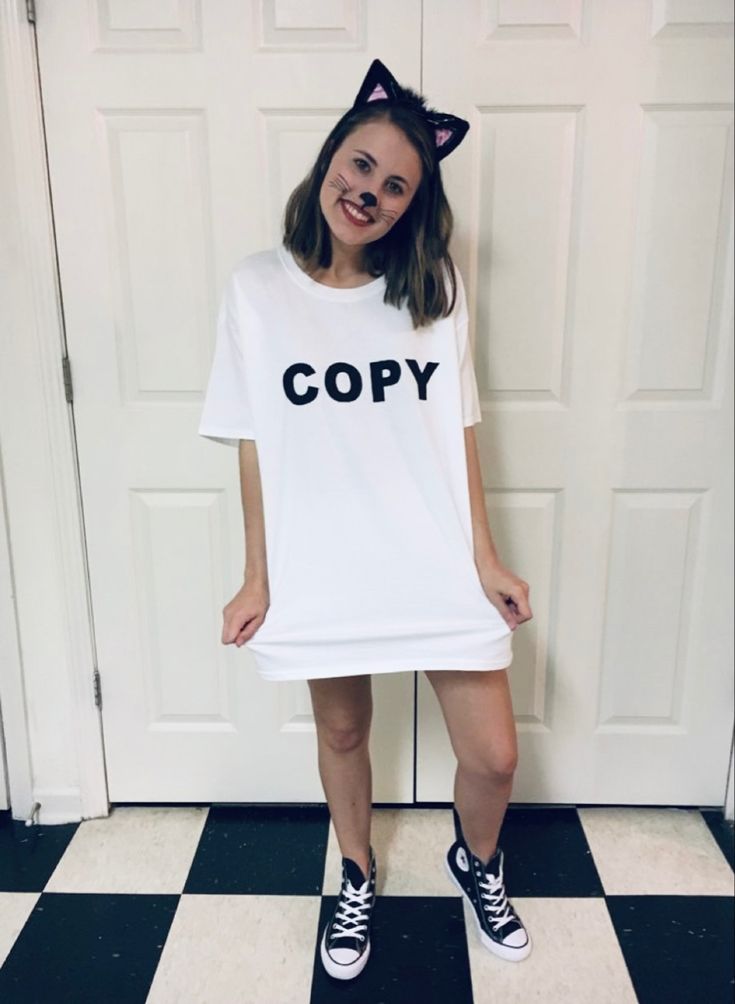 a woman wearing a white t - shirt with the word copy printed on it, standing in front of a black and white checkered floor