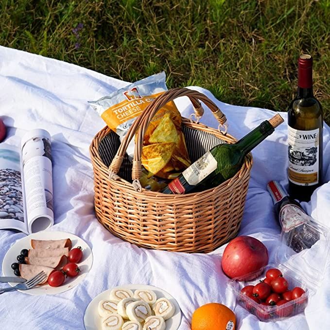 a picnic basket with food and wine on a blanket