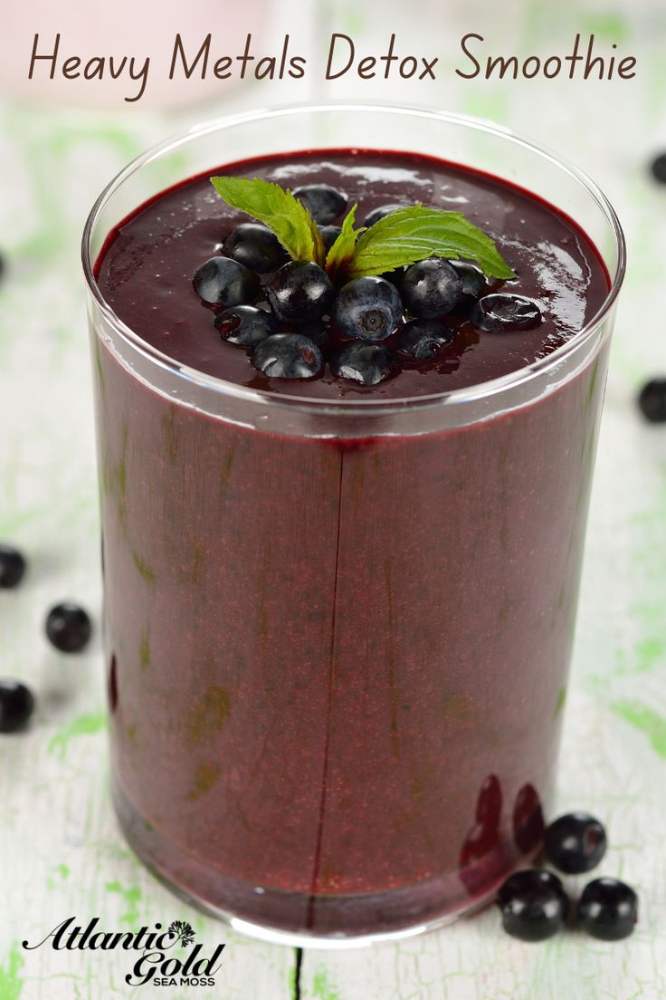 a smoothie with blueberries and mint on the side is ready to be eaten