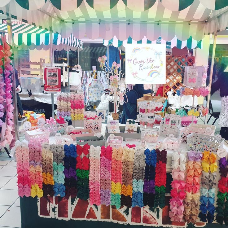 there are many different items on display at this market stall that is decorated with ribbons and streamers