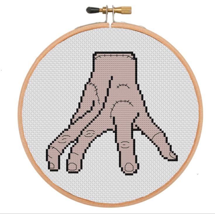 a cross stitched picture of a hand holding something in it's right hand