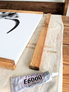 a painting is being displayed on a table next to a tube of glue and a brush