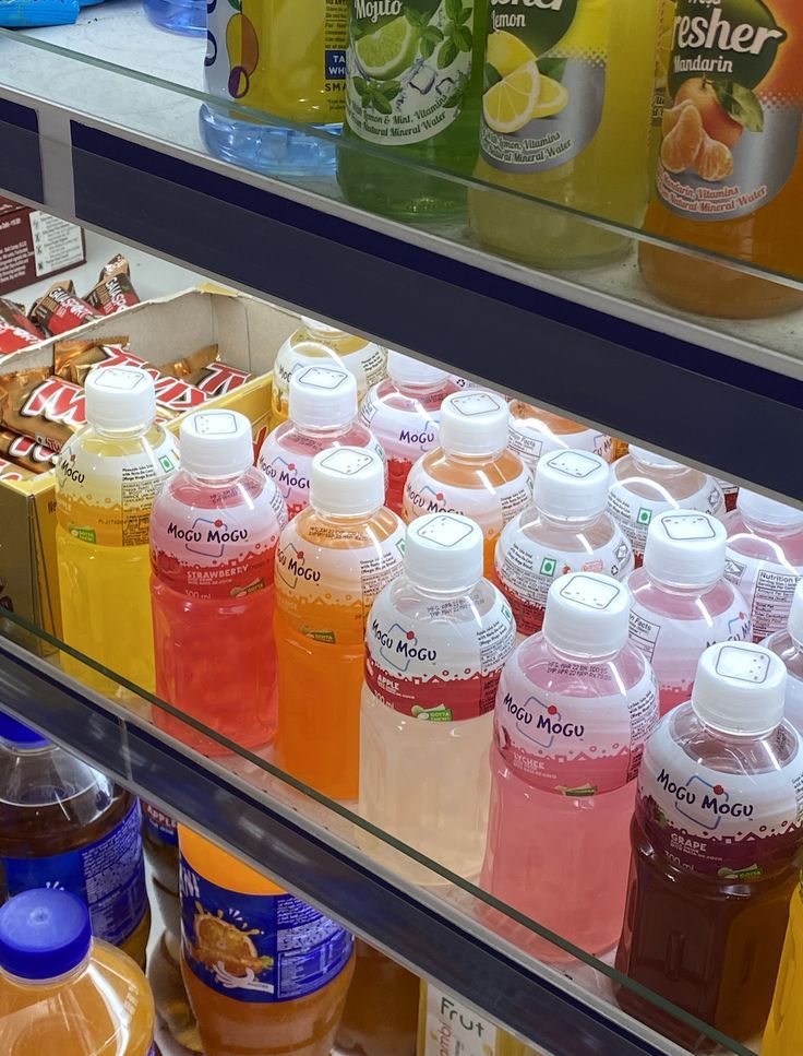 many bottles of juice are on display in a store