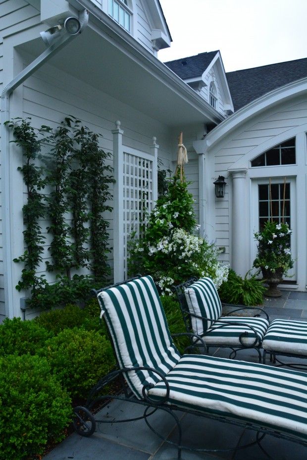 two lawn chairs sitting in front of a white house