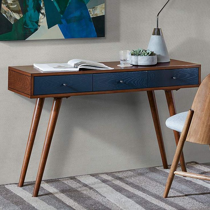 48" wide x 16" deep x 30" high. Weighs 59.47 lbs. Three-drawer Mid-Century Modern rectangular wood writing desk from the Howard collection by Madison Park. Warm pecan finish over rubberwood, MDF and oak veneer top construction. Navy blue finish drawer front. Bronze pull knobs. Includes three drawers. Desk top is 48" wide x 16" deep x 3/4" high. Clearance under top is 24" high. Each leg is 29" high x 2 1/4" wide. Distance between left to right leg is 41 1/2". Distance between front to back leg is 8 1/2". Drawer interior is 12 3/4" wide x 11" deep x 3 1/4" high. Holds up to 100 lbs. Leg assembly is required.  With an understated minimal aesthetic and retro-inspired touches, this Madison Park three-drawer rectangular desk offers plenty of storage space for stationery and home office essential Black Corner Desk, Metal Office Desk, Walnut Wood Desk, Natural Wood Desk, Black Metal Desk, Black Writing Desk, Blue Drawers, Living Room Lighting Tips, Wood Office Desk