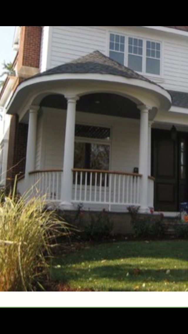 a white house with black shutters on the front porch