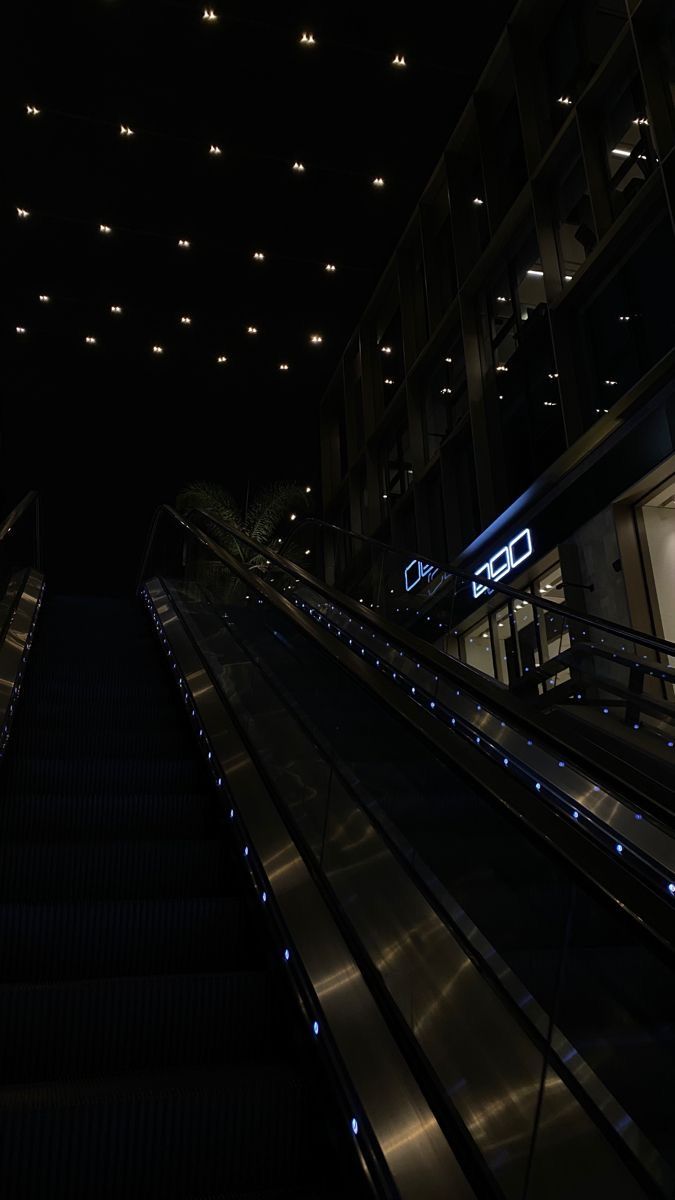 an escalator at night with lights on it