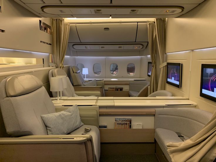 the inside of an airplane with seats and televisions