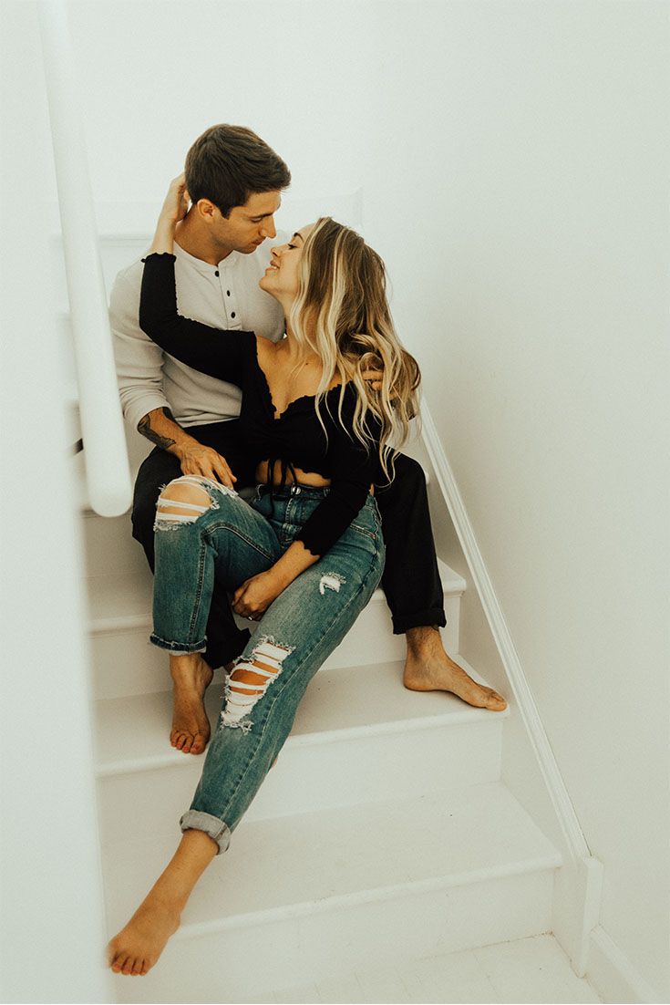 a man and woman sitting on the stairs kissing