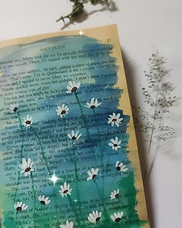 an altered book with daisies on it