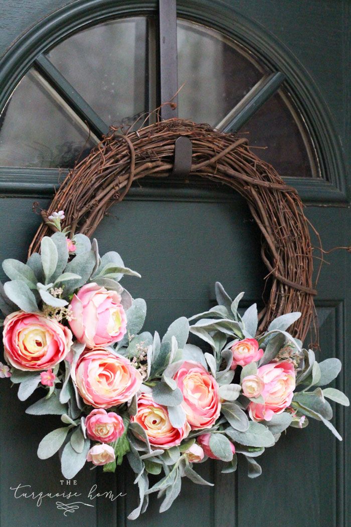 a wreath with pink flowers is hanging on the front door to give it an elegant touch