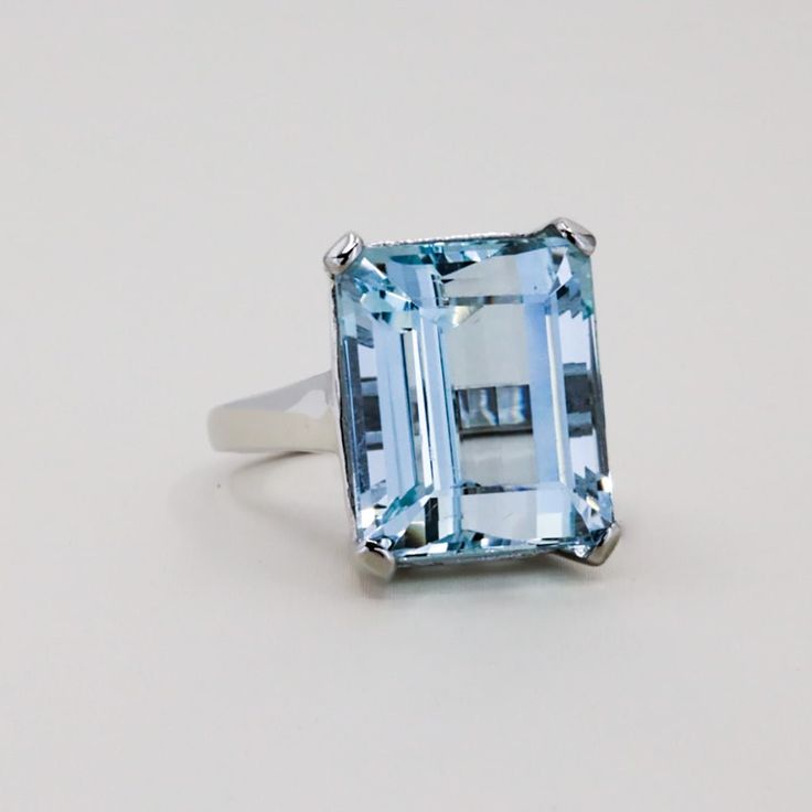 14k White gold rring with one rectangular aquamarine weighingapproximately 23.00 carats. 11.86 grams