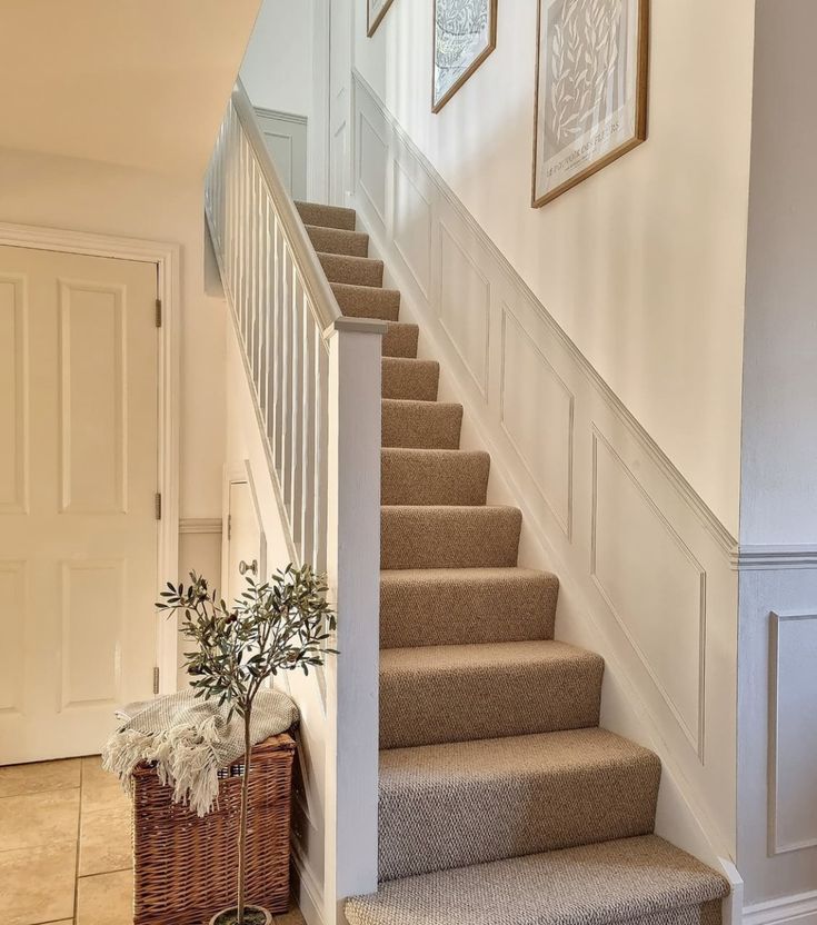 there is a potted plant on the stairs next to the carpeted steps in this house