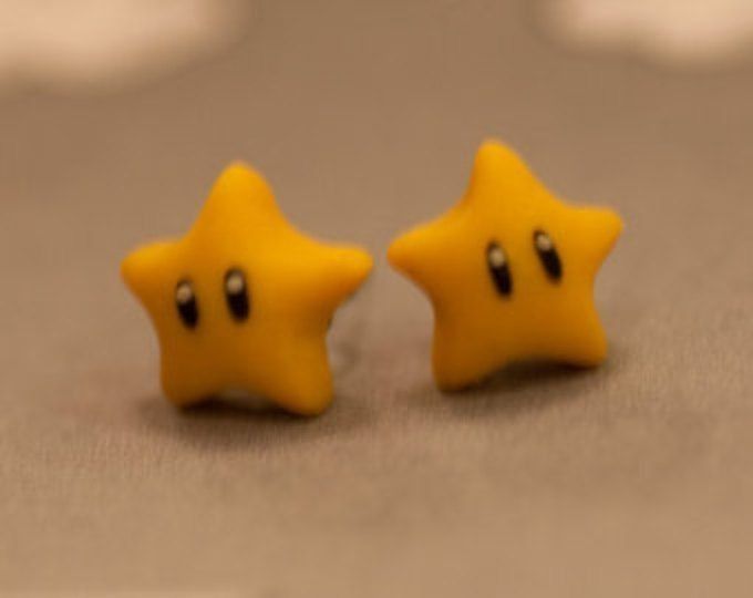 two yellow star shaped earrings sitting on top of a table