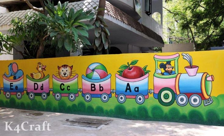 a mural on the side of a building depicting a train with children's pictures